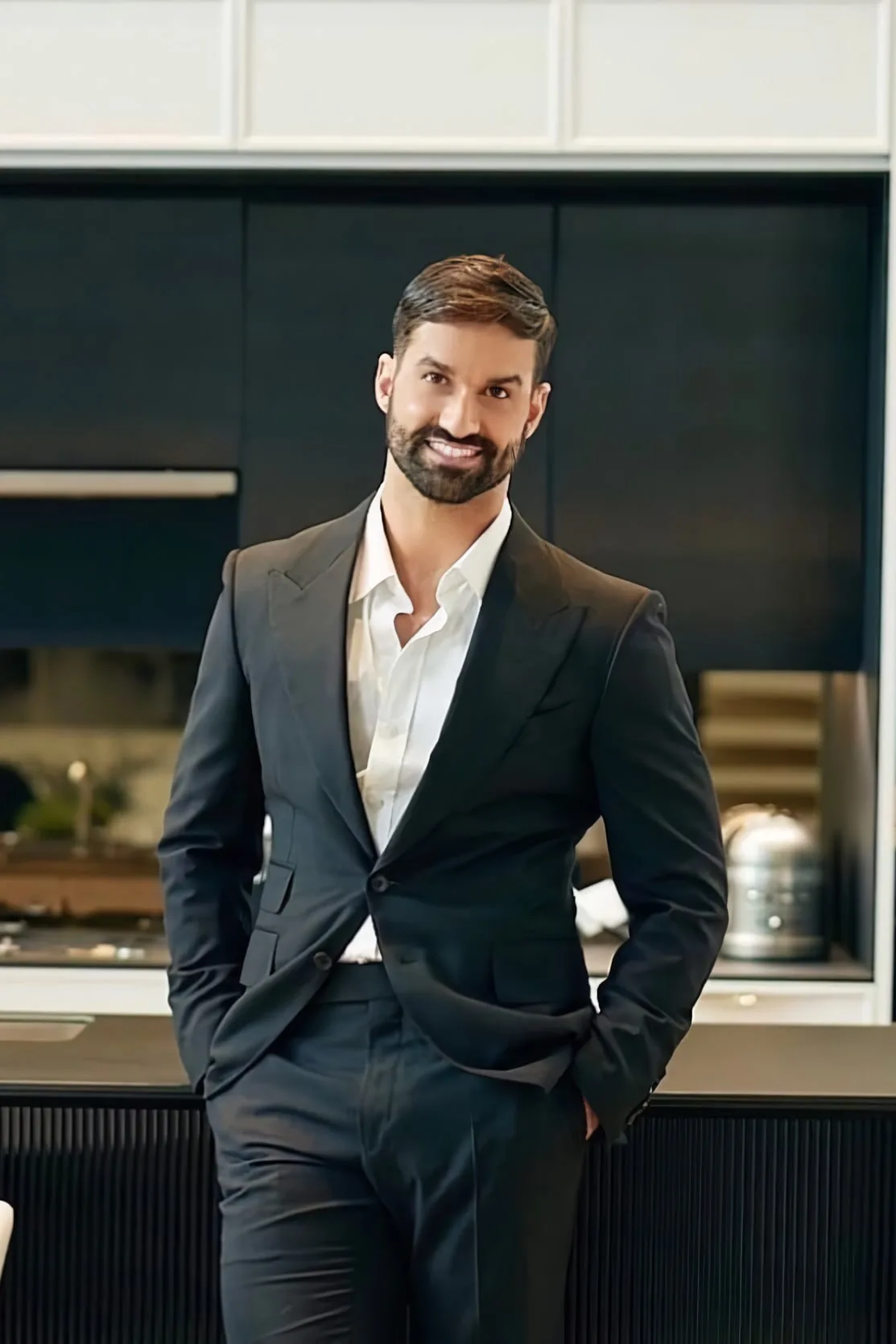 Iggy Gonçalves in a dark suit, standing in a modern kitchen.